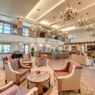 A spacious and elegantly designed lobby with comfortable seating and grand chandeliers.