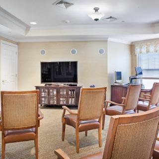 A community room with chairs arranged in front of a television.
