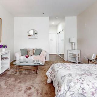 A cozy and elegantly decorated bedroom with a comfortable bed, small sofa, and stylish decor.