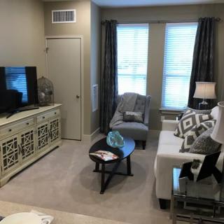 A cozy living room with a sofa, armchair, television, and decorative elements.