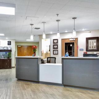 A modern office reception area with a central desk and stylish lighting.