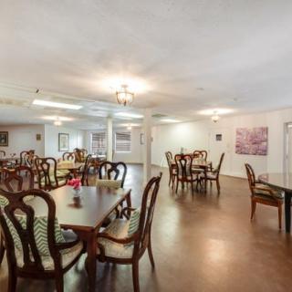 An empty dining room with multiple tables and chairs arranged neatly.