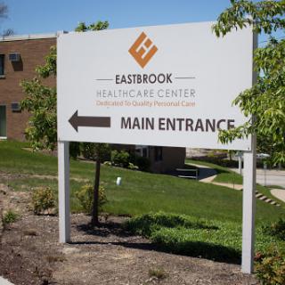 A sign directing visitors to the main entrance of Eastbrook Healthcare Center.