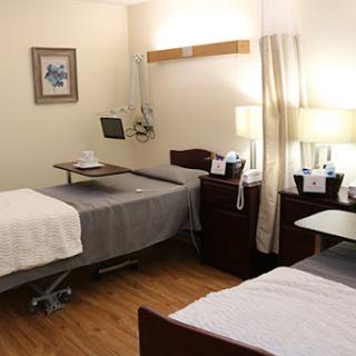 A well-equipped hospital room featuring two beds, designed for patient comfort and care.