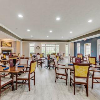 A spacious and well-lit dining area with multiple tables and chairs arranged neatly.