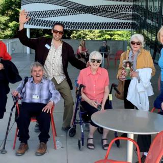 A group of people, including elderly individuals, enjoying an outdoor gathering.