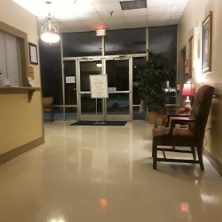 A quiet lobby area at night, featuring a welcoming entrance and comfortable seating.