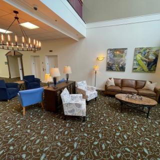 A spacious lobby area featuring various seating options, artwork on the walls, and elegant lighting.