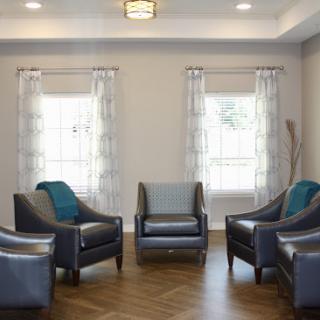 A modern living room setup featuring comfortable chairs and ample natural light.