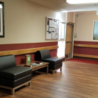 A quiet waiting area with seating and a wooden floor.