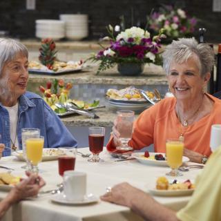 A group of seniors enjoying breakfast together, sharing conversation and laughter.