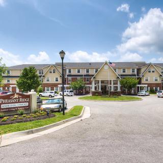 A well-maintained retirement home with a large entrance and neatly landscaped surroundings.