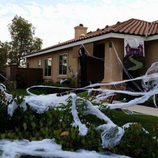 A house decorated for Halloween with spider webs and spooky elements.