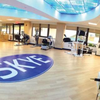 A modern gym with exercise equipment and a spacious workout area.