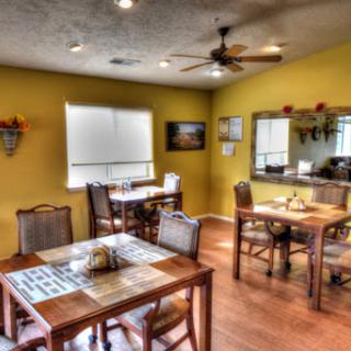 A cozy dining area featuring wooden tables and a warm yellow ambiance.