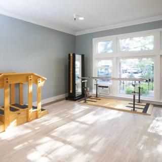 A bright and spacious exercise room featuring a ballet barre and various fitness equipment.