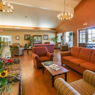 A spacious and well-decorated lobby with comfortable seating, plants, and large windows.