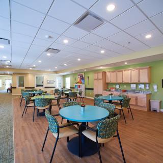 A modern dining area with round tables and colorful chairs in a bright, open space.