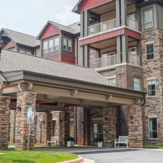 A modern apartment complex with a stone facade and covered entrance.