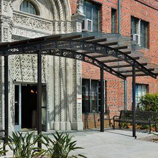 A building entrance with a decorative canopy and brick facade.