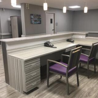 A modern office reception area featuring a spacious desk and comfortable seating.