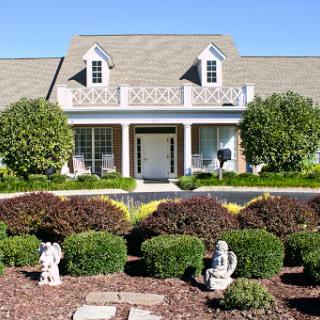 A beautifully landscaped home with decorative elements in the front yard.