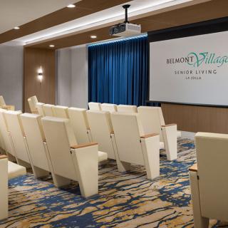A modern theater room with comfortable seating and a projector screen.