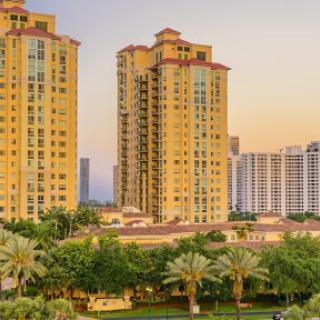 A captivating view of urban towers surrounded by lush greenery at sunset.