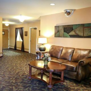 A cozy lobby area with a leather sofa, wooden table, and decorative elements.