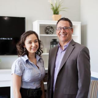 Two professionals smiling in an office setting.