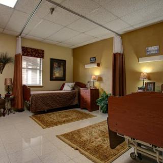 A cozy and well-decorated hospital room featuring a bed, bedside table, and welcoming decor.
