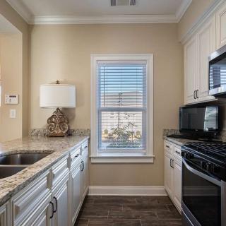 A modern kitchen interior with sleek appliances and a central window.