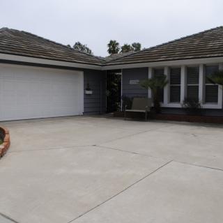 A suburban house with a large driveway and garage.
