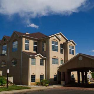A modern multi-story residential building under a blue sky.