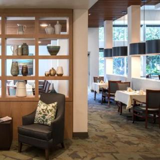 A modern restaurant interior with stylish decor, featuring a comfortable seating area and elegantly set dining tables.