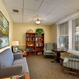 A cozy waiting room with comfortable seating, a bookshelf, and a warm atmosphere.