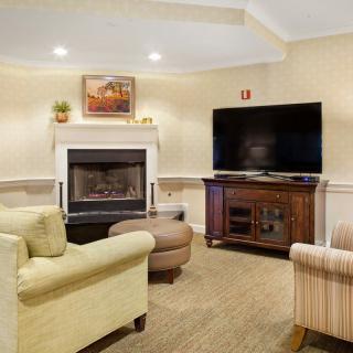 A cozy living room with a fireplace and a large television.