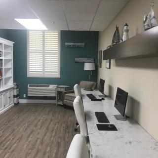 A modern office workspace with multiple desks and computers.