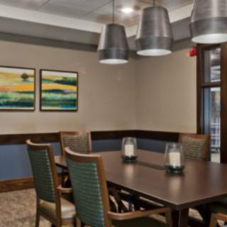 A modern dining room with elegant furnishings and decorative artwork on the wall.