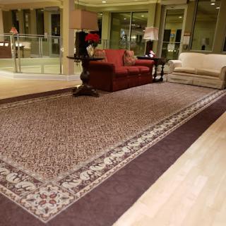 A cozy living room setup featuring a decorative rug and comfortable seating.