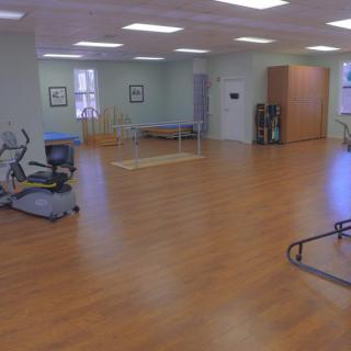 A spacious rehabilitation center with exercise equipment for physical therapy.