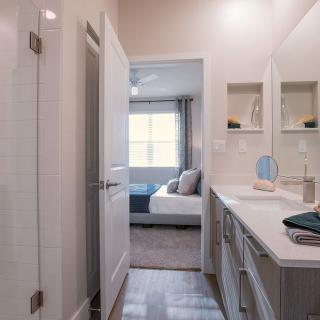 A modern bathroom with a view into an adjacent bedroom.