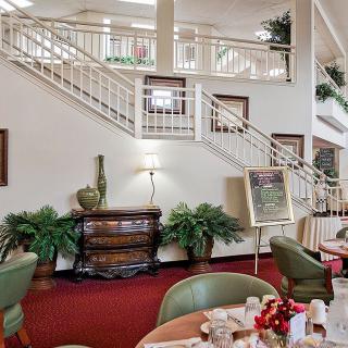 A cozy restaurant interior featuring elegant stairs and well-arranged dining tables.