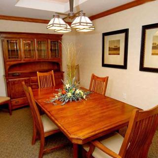 A cozy dining room with a wooden table and chairs, complemented by decorative elements and warm lighting.