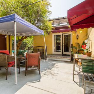 A cozy backyard patio with outdoor seating and canopy on a sunny day.
