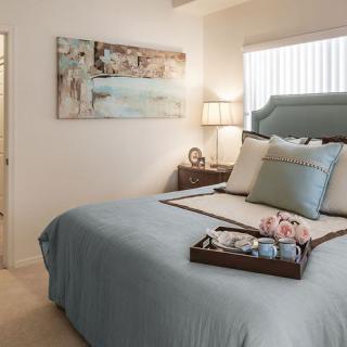 A cozy bedroom interior with a neatly made bed and elegant decor.