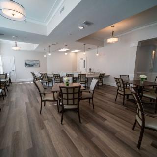 A modern dining room with elegant lighting and neatly arranged tables and chairs.