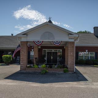 A building entrance decorated with American flags and patriotic bunting on a sunny day.