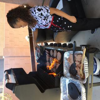 A person grilling hamburgers on an outdoor barbecue.