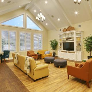 A spacious and modern living room with vaulted ceilings, warm lighting, and comfortable seating.